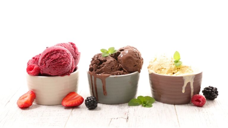 A variety of colorful ice cream scoops in bowls, showcasing different flavours.