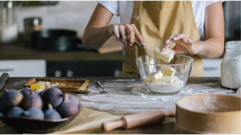 "A person mixing ingredients in a bowl, preparing butter or a similar food product.